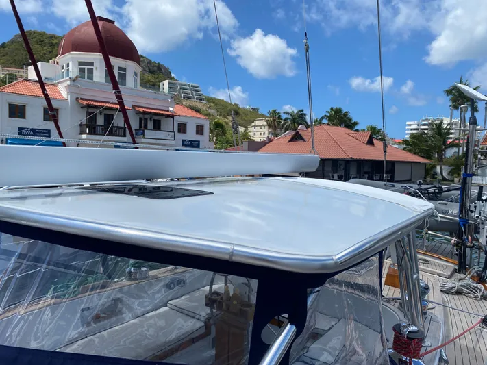 Pegasus Yacht Photos Pics 1984 Hallberg-Rassy 49 yacht docked near buildings with red roofs and clear blue sky.