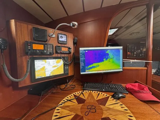 Pegasus Yacht Photos Pics Navigation station on a 1984 Hallberg-Rassy 49 yacht with maps and weather display.