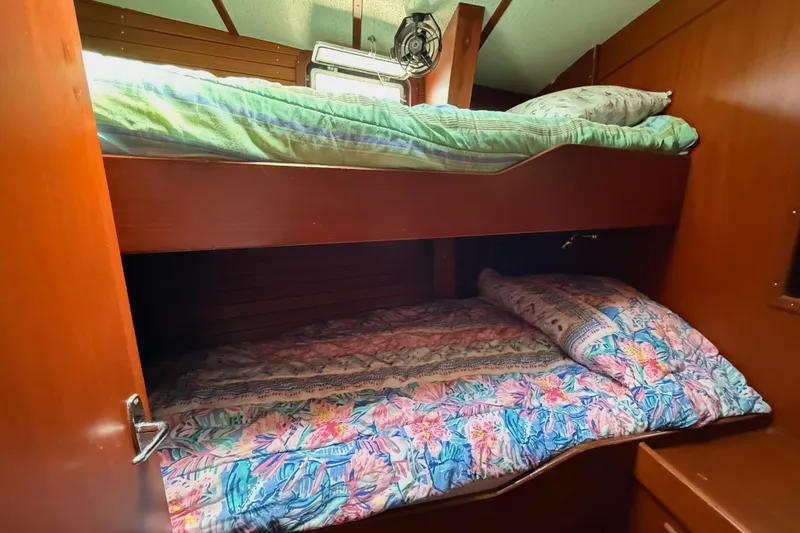 Pegasus Yacht Photos Pics Bunk beds in 1984 Hallberg-Rassy 49 yacht cabin with colorful bedding and wooden interior.