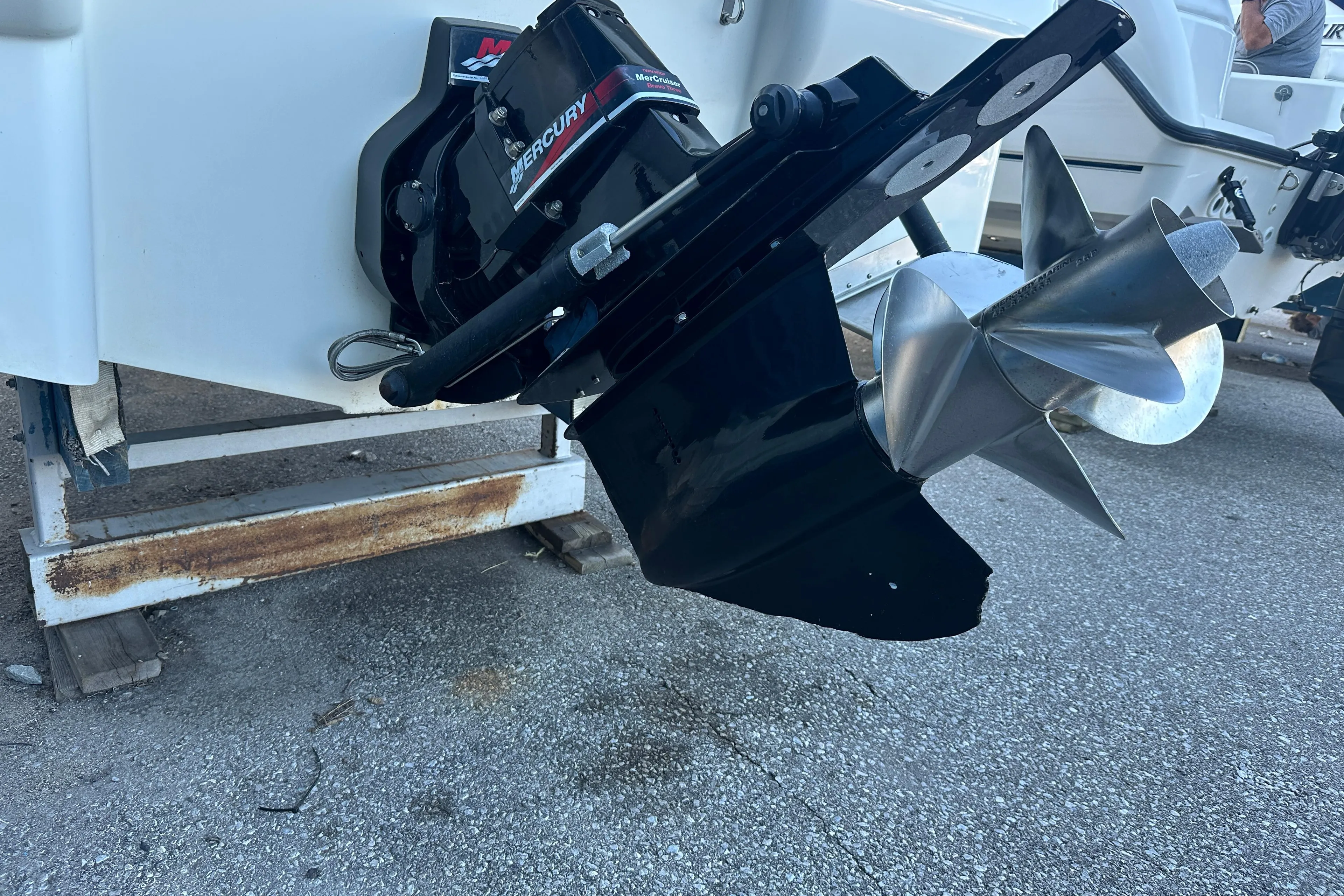 2004 Larson Cabrio 220 boat with Mercury outboard motor and propeller on display.