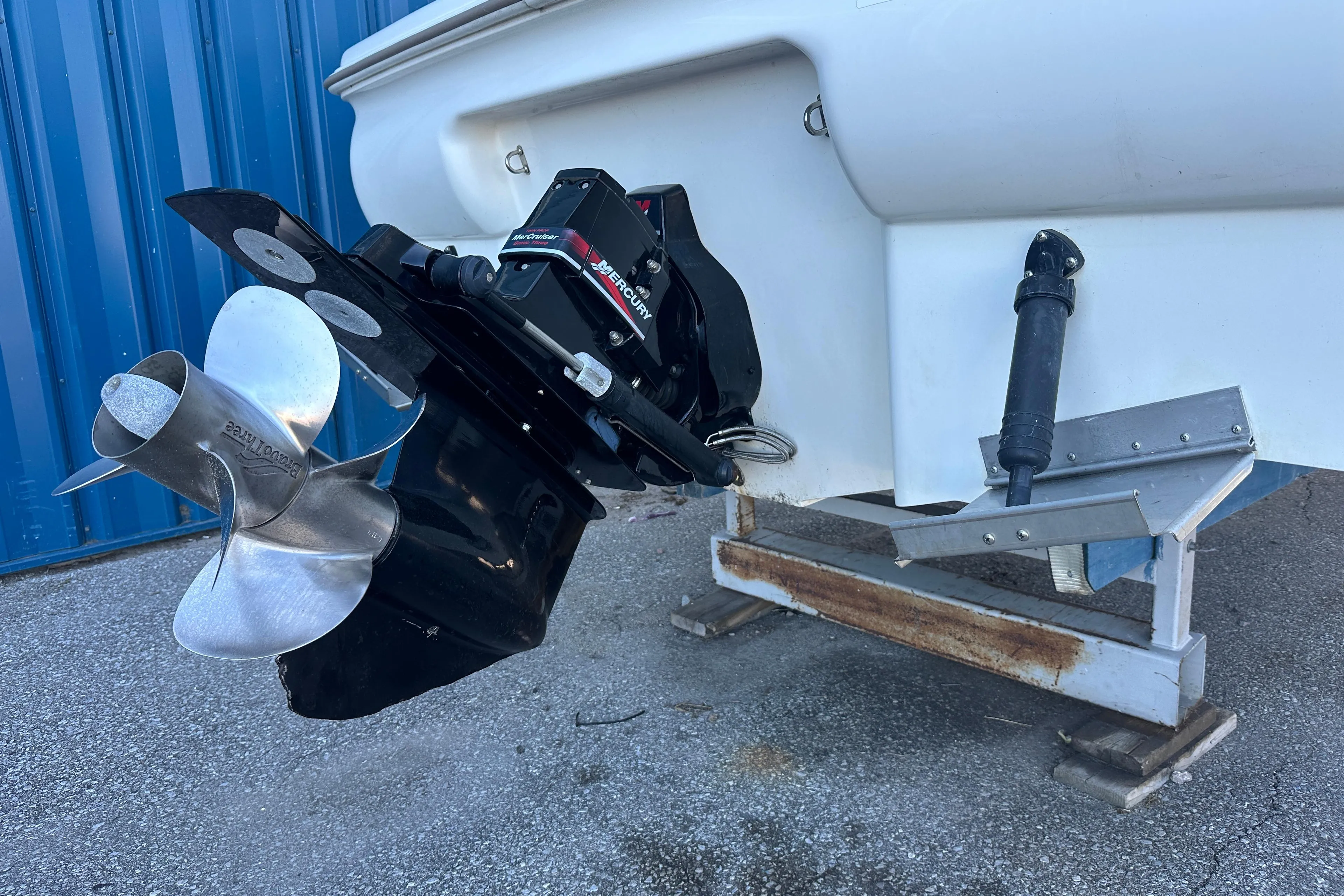 2004 Larson Cabrio 220 boat stern with propeller and outdrive, parked on a trailer.