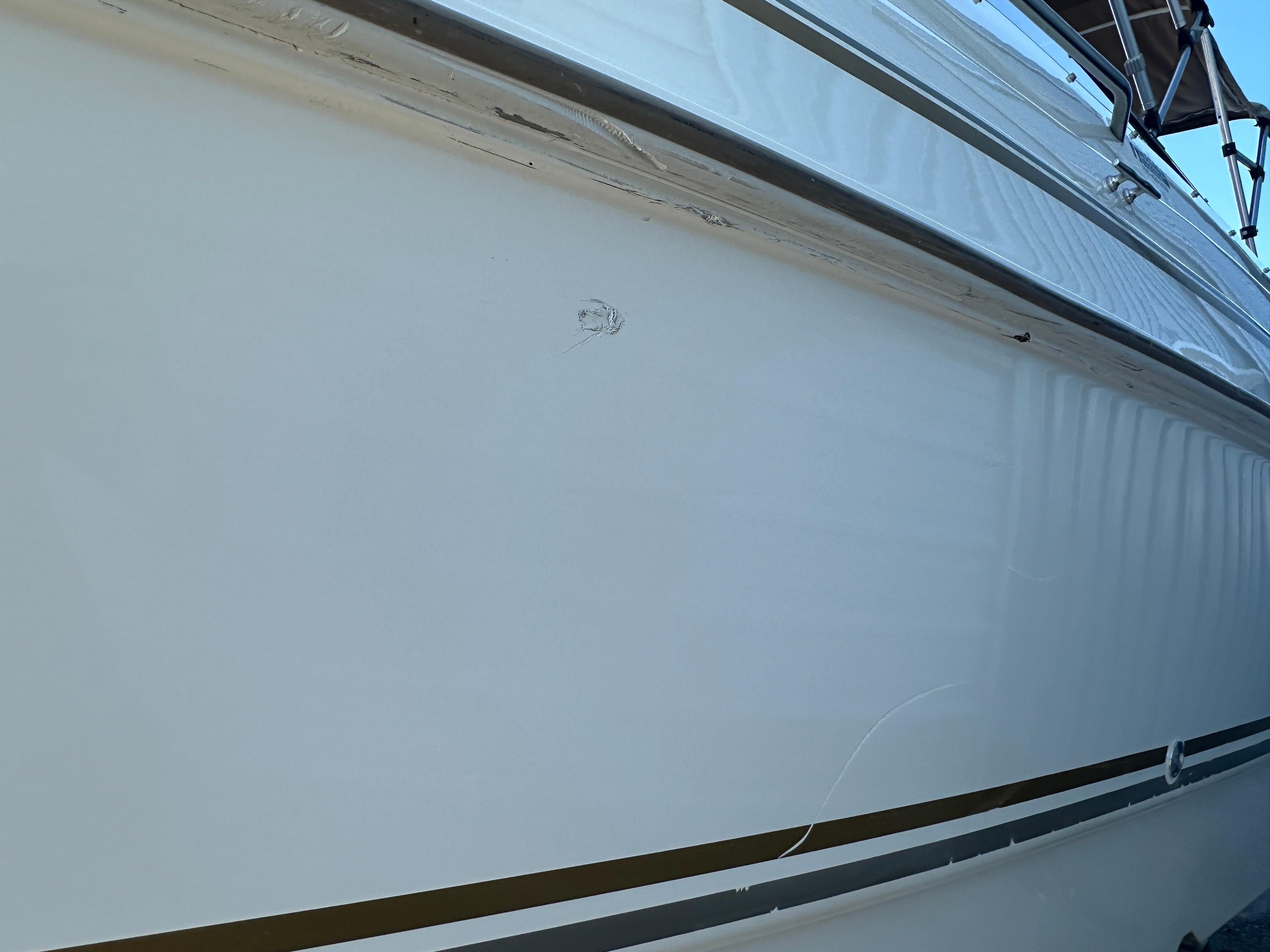 2004 Larson Cabrio 220 boat hull with minor scratches and clean white surface.