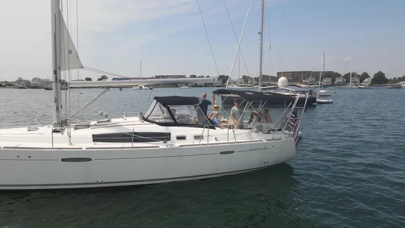 Rob Roy Yacht Photos Pics 2008 Beneteau Oceanis 46 sailboat on calm water with people onboard, clear sky background.