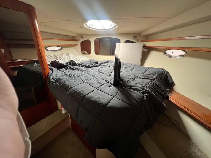 Serenity Yacht Photos Pics Interior cabin of 2007 Cruisers Yachts 370 Express with cozy bed and porthole windows.