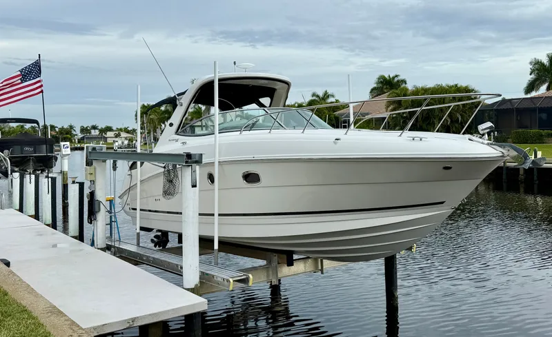 Just Us Yacht Photos Pics 2010 Sea Ray 310 Sundancer boat docked, with American flag and waterfront homes in background.