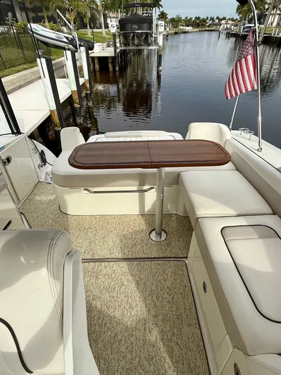 Just Us Yacht Photos Pics 2010 Sea Ray 310 Sundancer boat interior with seating and table, docked by a calm waterway.