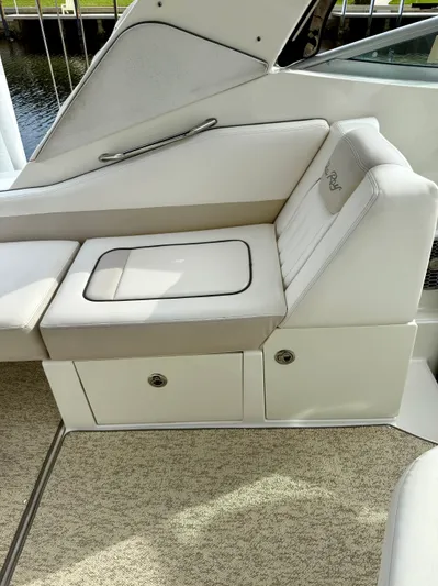 Just Us Yacht Photos Pics 2010 Sea Ray 310 Sundancer interior seating with storage compartments, featuring beige upholstery.
