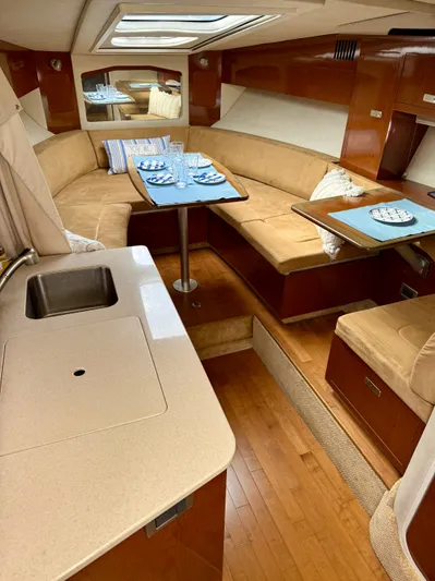 Just Us Yacht Photos Pics Luxurious interior of 2010 Sea Ray 310 Sundancer yacht with cozy seating and dining area.