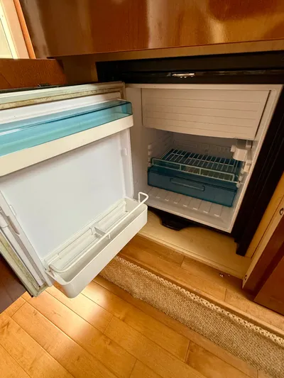 Just Us Yacht Photos Pics Open refrigerator inside 2010 Sea Ray 310 Sundancer boat, showcasing interior storage space.