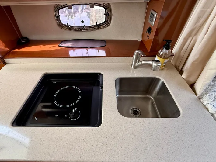 Just Us Yacht Photos Pics 2010 Sea Ray 310 Sundancer kitchen with sink and electric stove, featuring modern design.