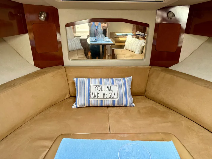 Just Us Yacht Photos Pics Interior of 2010 Sea Ray 310 Sundancer with cozy seating and nautical-themed pillow.