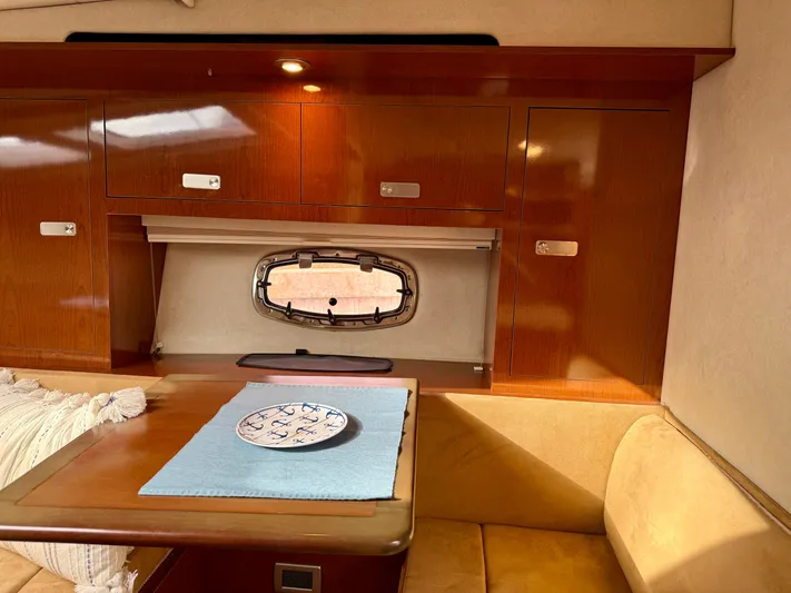 Just Us Yacht Photos Pics Interior of 2010 Sea Ray 310 Sundancer with wooden cabinets and cozy seating area.