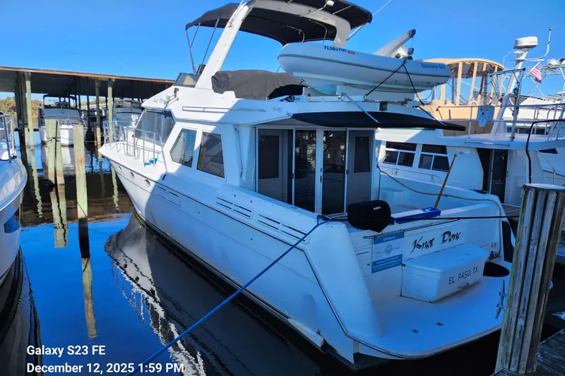 Knot Done Yacht Photos Pics 1999 Navigator 4800 CLASSIC yacht docked at marina, featuring sleek white design and upper deck.
