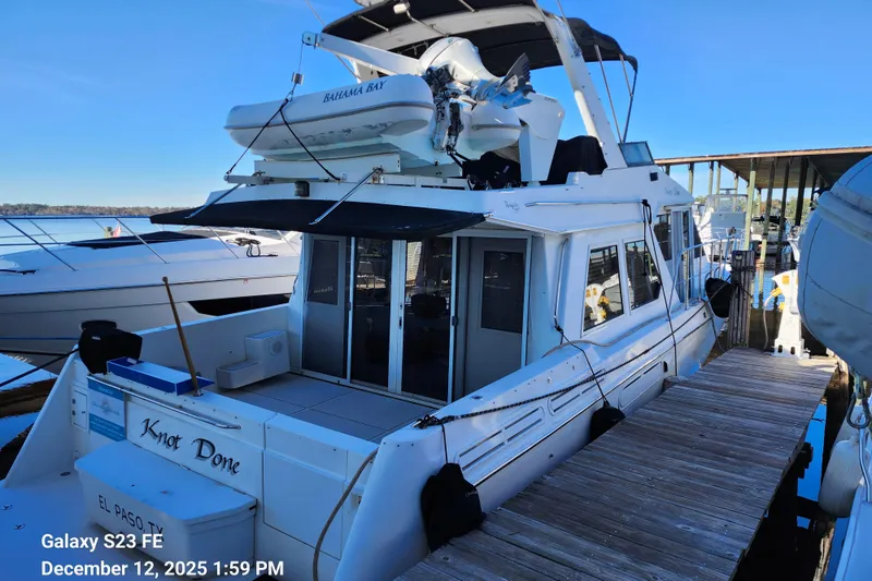Knot Done Yacht Photos Pics 1999 Navigator 4800 CLASSIC yacht docked, featuring upper deck and tender boat.