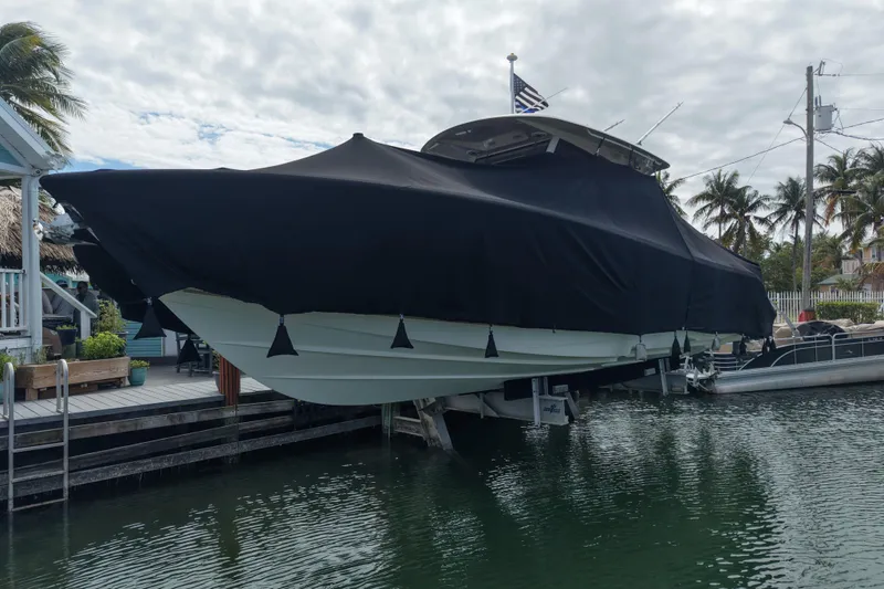  Yacht Photos Pics 2015 Cobia 344 Center Console boat covered and docked near palm trees.