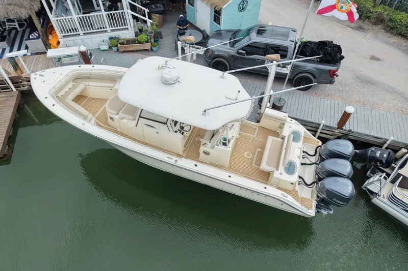  Yacht Photos Pics 2015 Cobia 344 Center Console boat docked, featuring triple outboard engines and spacious deck.