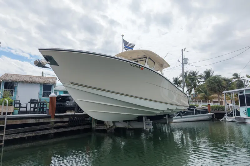 Yacht Photos Pics 2015 Cobia 344 Center Console boat docked near tropical waterfront homes.