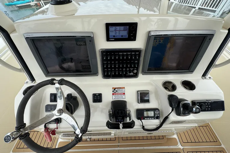  Yacht Photos Pics 2015 Cobia 344 Center Console dashboard with steering wheel, controls, and navigation screens.