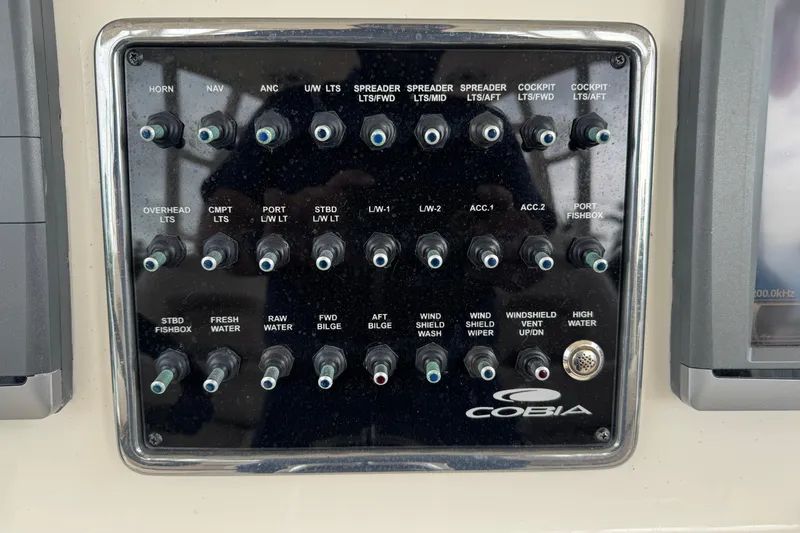  Yacht Photos Pics Control panel of a 2015 Cobia 344 Center Console boat with labeled switches.