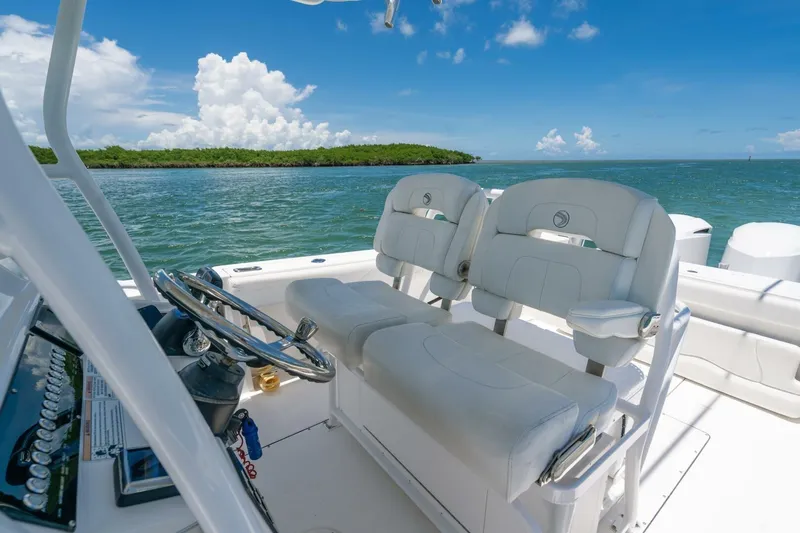  Yacht Photos Pics 2017 Edgewater 318CC boat interior with dual seats, steering wheel, and ocean view.