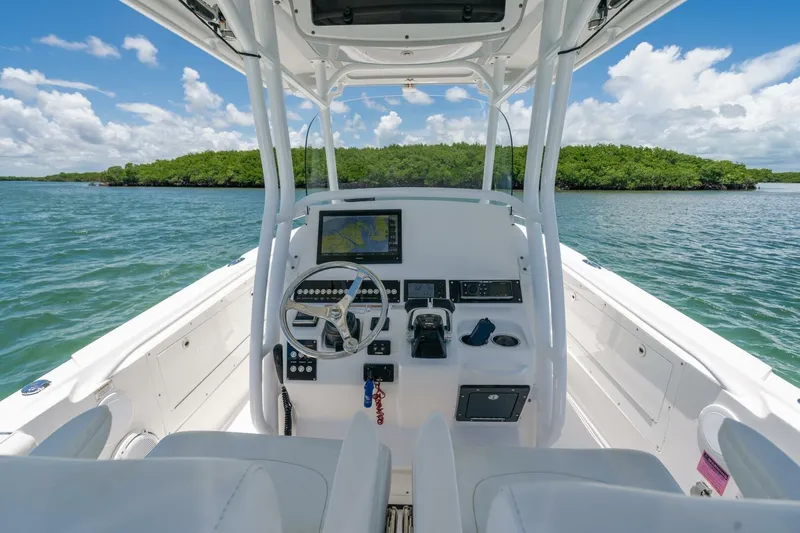  Yacht Photos Pics 2017 Edgewater 318CC boat interior with steering wheel and navigation system on open water.