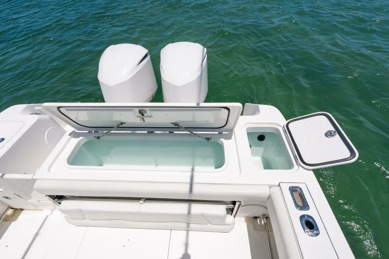  Yacht Photos Pics 2017 Edgewater 318CC boat with open storage compartments and dual engines on water.