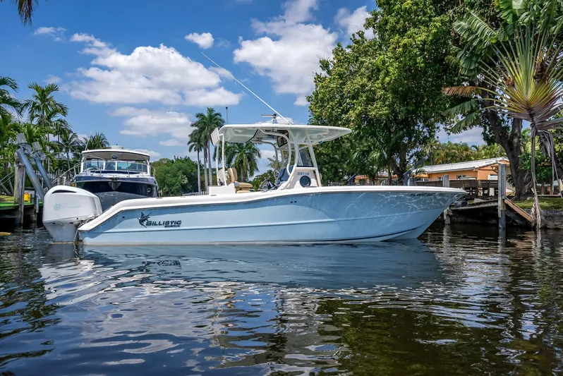  Yacht Photos Pics 2020 Key West Billistic 281 boat on calm water, surrounded by trees and blue sky.