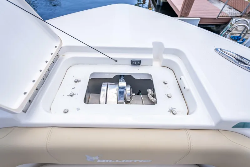  Yacht Photos Pics 2020 Key West Billistic 281 boat anchor compartment with open hatch, showcasing winch mechanism.