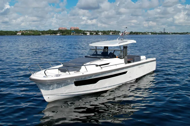 T/t Sophia Yacht Photos Pics 2022 Nimbus T11 boat cruising on a calm, scenic waterway under a partly cloudy sky.
