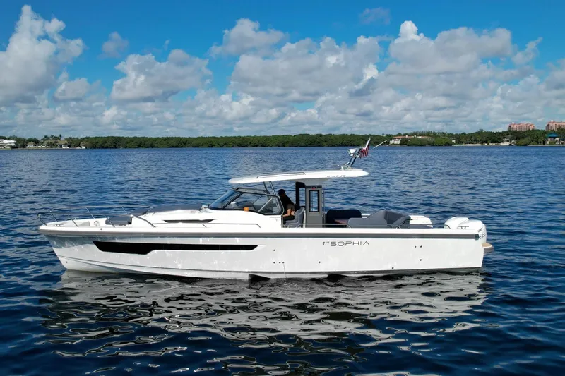 T/t Sophia Yacht Photos Pics 2022 Nimbus T11 boat cruising on a calm, scenic lake under a partly cloudy sky.