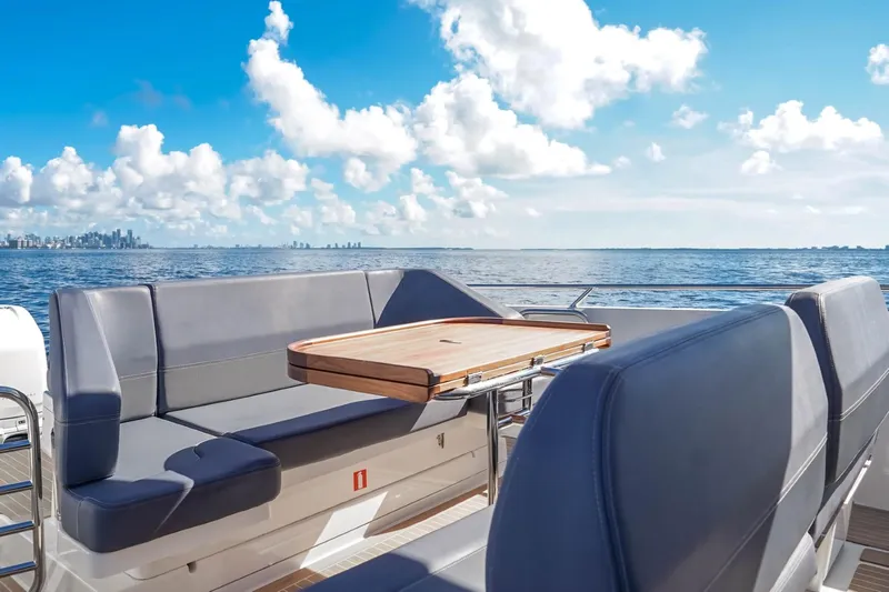 T/t Sophia Yacht Photos Pics Luxurious Nimbus T11 2022 boat with seating and table, ocean view, and city skyline.