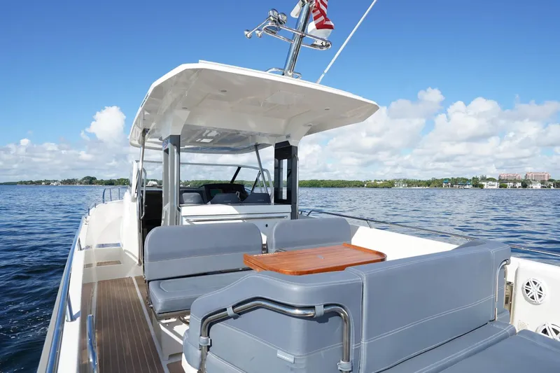 T/t Sophia Yacht Photos Pics Nimbus T11 2022 boat with seating area on calm water under blue sky.