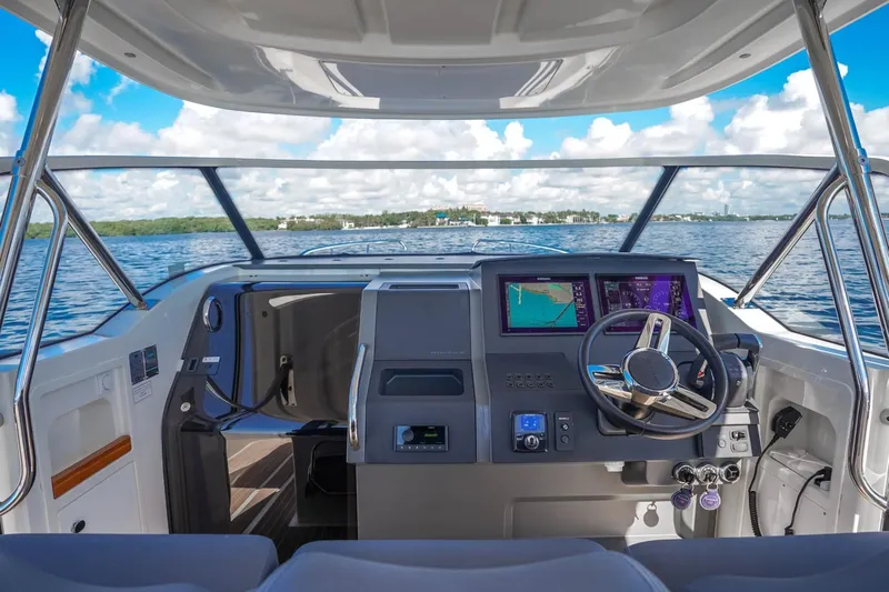 T/t Sophia Yacht Photos Pics Cockpit view of 2022 Nimbus T11 boat with modern navigation system on open water.