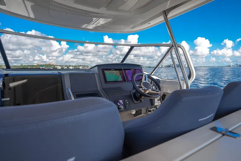 T/t Sophia Yacht Photos Pics Helm of 2022 Nimbus T11 boat with navigation screens, steering wheel, and ocean view.