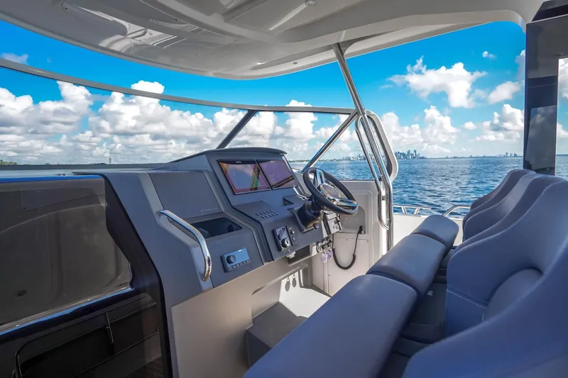 T/t Sophia Yacht Photos Pics Interior view of 2022 Nimbus T11 boat cockpit with ocean and city skyline.