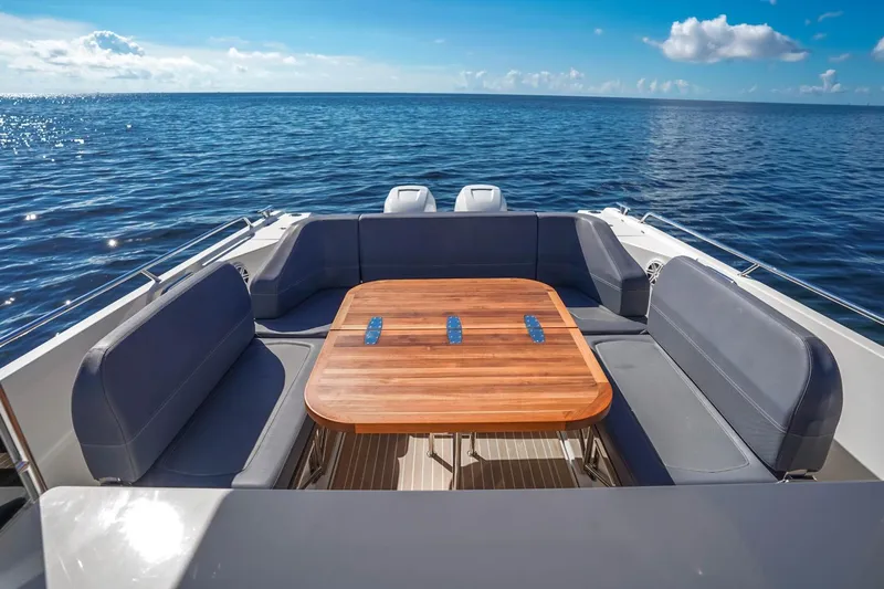 T/t Sophia Yacht Photos Pics 2022 Nimbus T11 boat with wooden table and seating, on calm ocean waters.