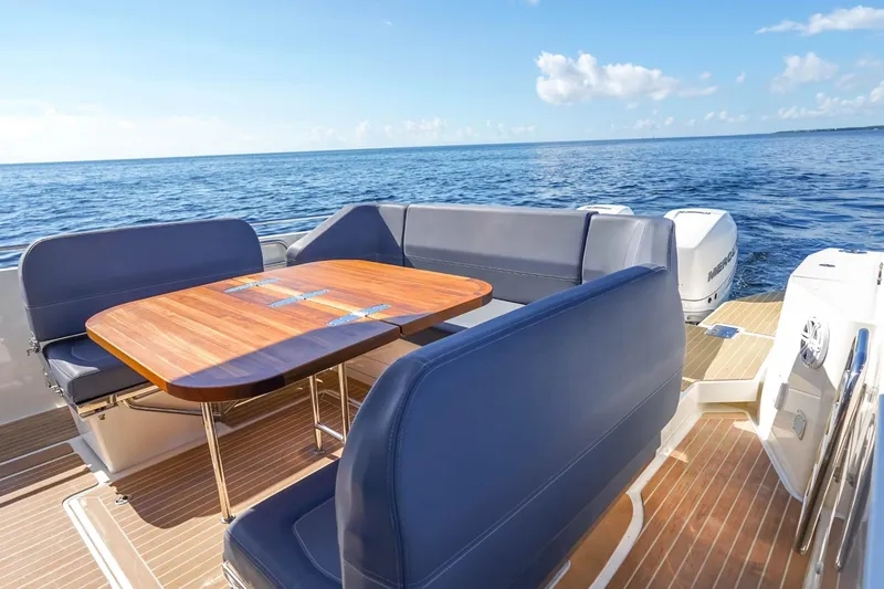 T/t Sophia Yacht Photos Pics Luxurious 2022 Nimbus T11 boat interior with wooden table and ocean view.