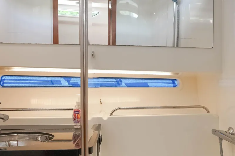 T/t Sophia Yacht Photos Pics Modern bathroom interior of 2022 Nimbus T11 yacht with sleek fixtures and blue window shade.