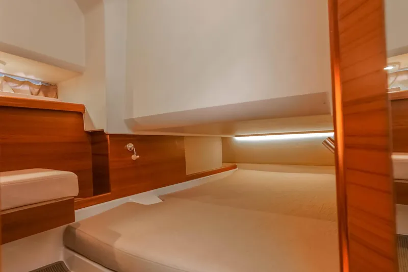 T/t Sophia Yacht Photos Pics 2022 Nimbus T11 cabin interior with wooden accents and cozy sleeping area.