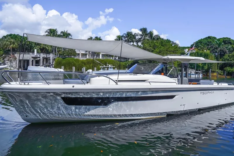 T/t Sophia Yacht Photos Pics 2022 Nimbus T11 boat with canopy, docked in a scenic marina setting.