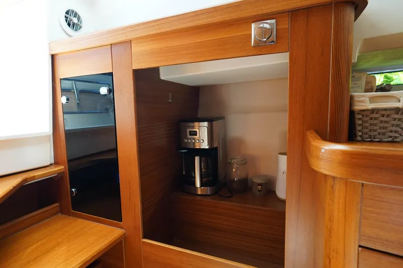 T/t Sophia Yacht Photos Pics Modern wooden kitchen interior on Nimbus T11, featuring a coffee maker and storage space.