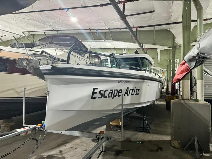 Escape Artist Yacht Photos Pics 2020 Axopar 37 Cross Cabin BRABUS boat named "Escape Artist" in indoor storage.