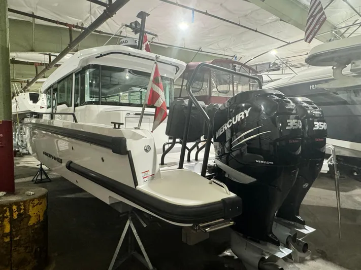 Escape Artist Yacht Photos Pics 2020 Axopar 37 Cross Cabin BRABUS with twin Mercury 350 engines in a showroom.