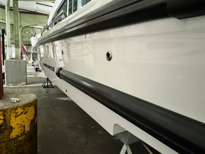 Escape Artist Yacht Photos Pics 2020 Axopar 37 Cross Cabin BRABUS in a workshop, side view of hull detailing.