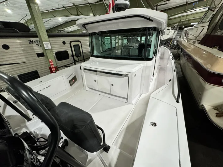 Escape Artist Yacht Photos Pics 2020 Axopar 37 Cross Cabin BRABUS in a storage facility, showcasing sleek design and spacious deck.