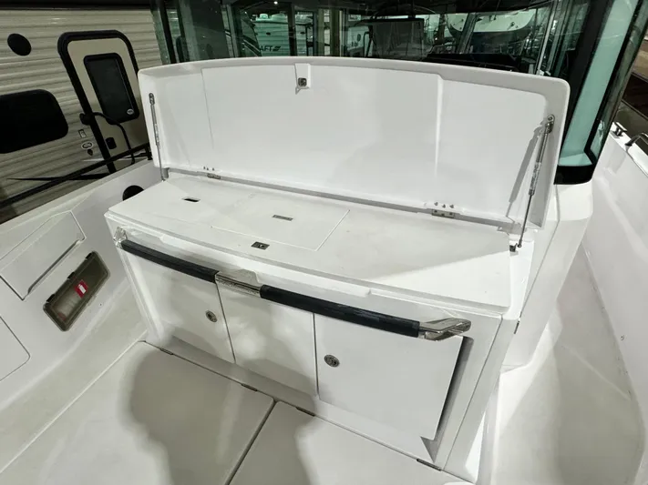 Escape Artist Yacht Photos Pics 2020 Axopar 37 Cross Cabin BRABUS boat interior with white storage compartment.