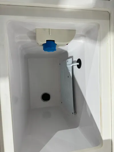 Escape Artist Yacht Photos Pics 2020 Axopar 37 Cross Cabin BRABUS storage compartment, featuring a drain and white interior.