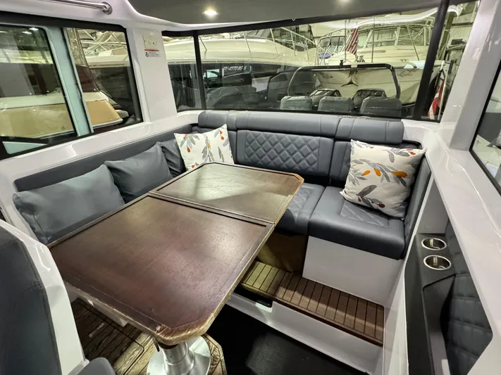 Escape Artist Yacht Photos Pics Interior of 2020 Axopar 37 Cross Cabin BRABUS with seating and table.