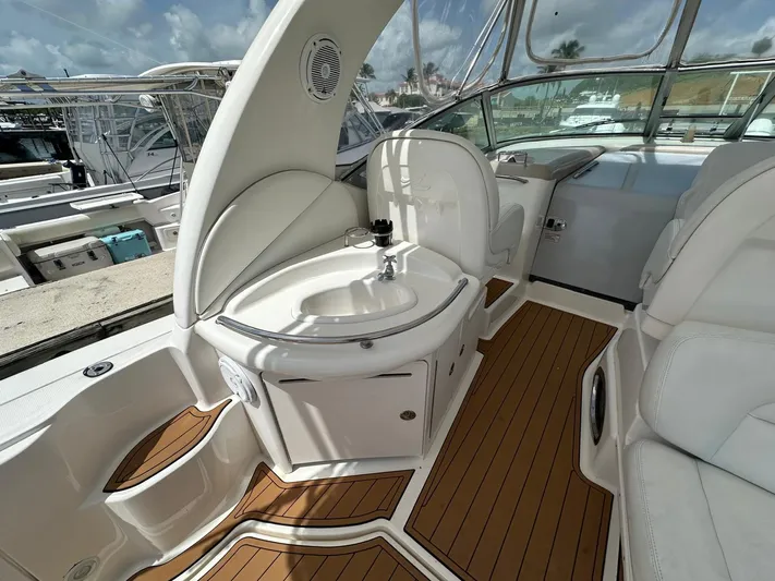  Yacht Photos Pics 2004 Sea Ray 340 Sundancer interior with sink and seating, featuring teak flooring.