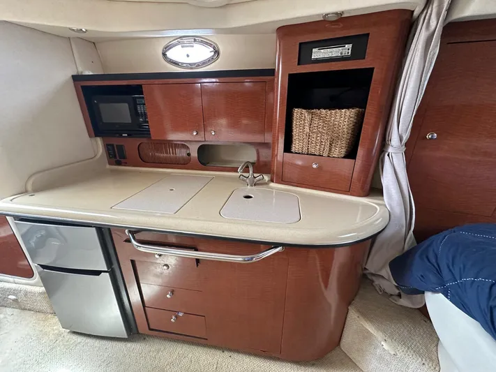  Yacht Photos Pics Luxurious 2004 Sea Ray 340 Sundancer cabin kitchen with wood cabinetry and modern appliances.